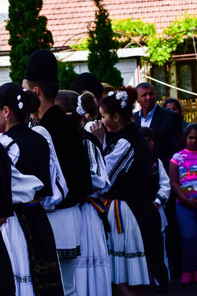身着民族服装的罗马尼亚民间舞蹈家 用传统的黑色图案缝制而成 男人戴着传统的圆形黑色布帽 女人戴着带有流苏的黑色围巾 — 图库照片