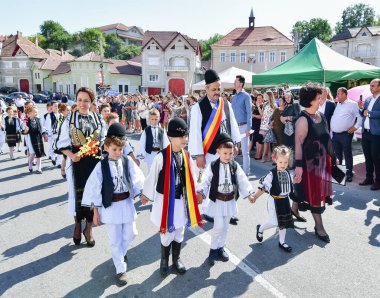 Sibiu Çayırı 'ndaki erkekler ve kızlar pastoral kostümler içinde yuvarlak kumaş şapkalar, etekli bir gömlek, pantolon, geniş bir deri kemer, göğüs ve kızlar beyaz bir fular, yakalı bir gömlek ve üç renkli bir kemer giyerler.