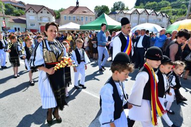 Sibiu Çayırı 'ndaki erkekler ve kızlar pastoral kostümler içinde yuvarlak kumaş şapkalar, etekli bir gömlek, pantolon, geniş bir deri kemer, göğüs ve kızlar beyaz bir fular, yakalı bir gömlek ve üç renkli bir kemer giyerler.