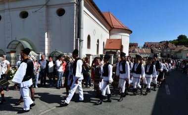 Sibiu Çayırı 'ndaki erkekler ve kızlar pastoral kostümler içinde yuvarlak kumaş şapkalar, etekli bir gömlek, pantolon, geniş bir deri kemer, göğüs ve kızlar beyaz bir fular, yakalı bir gömlek ve üç renkli bir kemer giyerler.