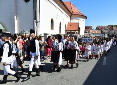 Sibiu Çayırı 'ndaki erkekler ve kızlar pastoral kostümler içinde yuvarlak kumaş şapkalar, etekli bir gömlek, pantolon, geniş bir deri kemer, göğüs ve kızlar beyaz bir fular, yakalı bir gömlek ve üç renkli bir kemer giyerler.