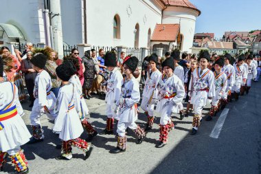 Sibiu Çayırı 'ndaki erkekler ve kızlar pastoral kostümler içinde yuvarlak kumaş şapkalar, etekli bir gömlek, pantolon, geniş bir deri kemer, göğüs ve kızlar beyaz bir fular, yakalı bir gömlek ve üç renkli bir kemer giyerler.