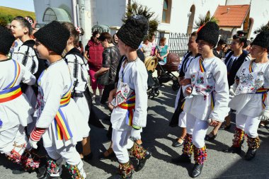 Sibiu Çayırı 'ndaki erkekler ve kızlar pastoral kostümler içinde yuvarlak kumaş şapkalar, etekli bir gömlek, pantolon, geniş bir deri kemer, göğüs ve kızlar beyaz bir fular, yakalı bir gömlek ve üç renkli bir kemer giyerler.