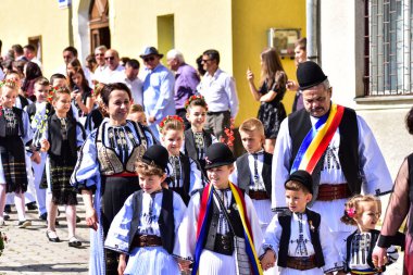 Sibiu Çayırı 'ndaki erkekler ve kızlar pastoral kostümler içinde yuvarlak kumaş şapkalar, etekli bir gömlek, pantolon, geniş bir deri kemer, göğüs ve kızlar beyaz bir fular, yakalı bir gömlek ve üç renkli bir kemer giyerler.