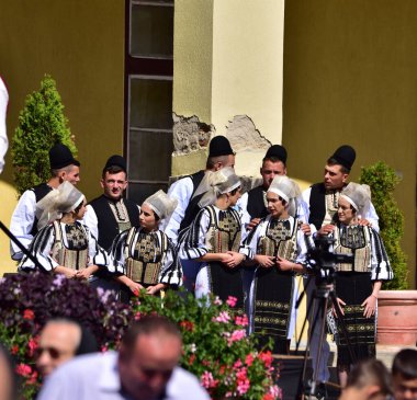Sibiu Çayırı 'ndaki erkekler ve kızlar pastoral kostümler içinde yuvarlak kumaş şapkalar, etekli bir gömlek, pantolon, geniş bir deri kemer, göğüs ve kızlar beyaz bir fular, yakalı bir gömlek ve üç renkli bir kemer giyerler.