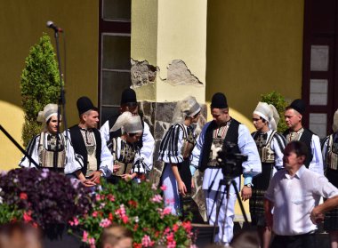Sibiu Çayırı 'ndaki erkekler ve kızlar pastoral kostümler içinde yuvarlak kumaş şapkalar, etekli bir gömlek, pantolon, geniş bir deri kemer, göğüs ve kızlar beyaz bir fular, yakalı bir gömlek ve üç renkli bir kemer giyerler.