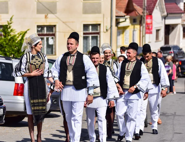 Sibiu Çayırı 'ndaki erkekler ve kızlar pastoral kostümler içinde yuvarlak kumaş şapkalar, etekli bir gömlek, pantolon, geniş bir deri kemer, göğüs ve kızlar beyaz bir fular, yakalı bir gömlek ve üç renkli bir kemer giyerler.