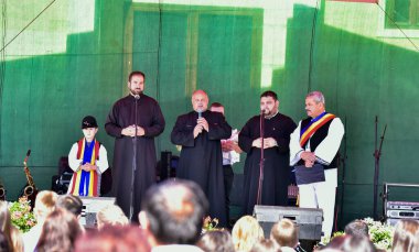 Rahipler ve Romanya Belediye Başkanı Sibiului komünü, rahipler siyah kumaştan kilise kıyafetleri giyiyorlar ve belediye başkanı geleneksel siyah motiflerle dikilmiş, siyah bir elbise giyiyor. 