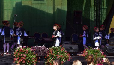 Romanya 'lı kızlar geleneksel siyah motiflerle dikilmiş çarşaflardan yapılmış ulusal çoban kıyafeti giyiyorlar