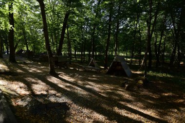 Sibiu Ormanı 'ndaki çingenelerin kamp ve satraları, demircinin atölyesinin düzenlendiği büyük çadırı, çingenelerin uyuduğu küçük çadırı, barakalı arabayı ve masayı kapsıyor.