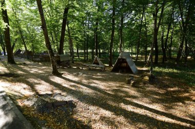Sibiu Ormanı 'ndaki çingenelerin kamp ve satraları, demircinin atölyesinin düzenlendiği büyük çadırı, çingenelerin uyuduğu küçük çadırı, barakalı arabayı ve masayı kapsıyor.