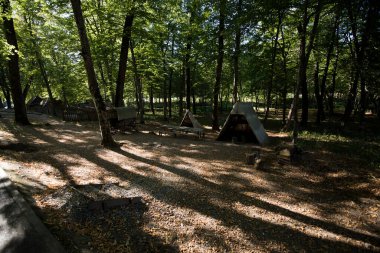 Sibiu Ormanı 'ndaki çingenelerin kamp ve satraları, demircinin atölyesinin düzenlendiği büyük çadırı, çingenelerin uyuduğu küçük çadırı, barakalı arabayı ve masayı kapsıyor.