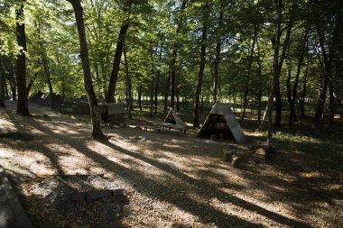 Sibiu Ormanı 'ndaki çingenelerin kamp ve satraları, demircinin atölyesinin düzenlendiği büyük çadırı, çingenelerin uyuduğu küçük çadırı, barakalı arabayı ve masayı kapsıyor.