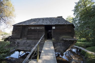 The floating mill is a rectangular construction, with plank walls and a gabled roof, covered with fir shingles mounted on two vessels of different sizes, with a shovel  shaped prow