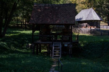 Mısır unu için el değirmeni ya da değirmeni merkezi ahşap saplı iki değirmen taşından oluşur, iki ayaklı destek çubuğu ile desteklenir, zemin seviyesinde dört tabanı vardır.