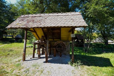 Mısır unu için el değirmeni ya da değirmeni merkezi ahşap saplı iki değirmen taşından oluşur, iki ayaklı destek çubuğu ile desteklenir, zemin seviyesinde dört tabanı vardır.