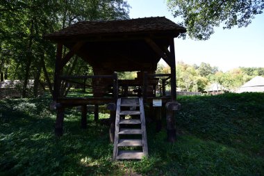 Mısır unu için el değirmeni ya da değirmeni merkezi ahşap saplı iki değirmen taşından oluşur, iki ayaklı destek çubuğu ile desteklenir, zemin seviyesinde dört tabanı vardır.