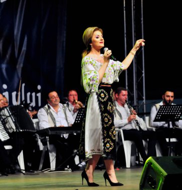 Banat, Romaniafolk kostüm giymiş sanatçı, geleneksel örgü işlemeli mavi veya kırmızı iplik, kucak, yelek, yarasa ve fotoğraf önde ve arkada pamuk iplik, kavana ve ipek iplik ile dikilmiş