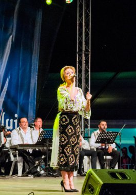 Banat, Romaniafolk kostüm giymiş sanatçı, geleneksel örgü işlemeli mavi veya kırmızı iplik, kucak, yelek, yarasa ve fotoğraf önde ve arkada pamuk iplik, kavana ve ipek iplik ile dikilmiş