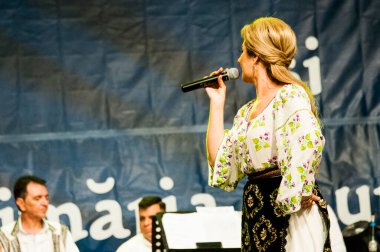 Banat, Romaniafolk kostüm giymiş sanatçı, geleneksel örgü işlemeli mavi veya kırmızı iplik, kucak, yelek, yarasa ve fotoğraf önde ve arkada pamuk iplik, kavana ve ipek iplik ile dikilmiş