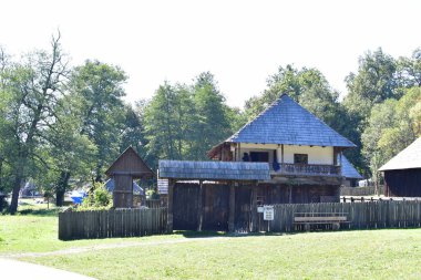 Geleneksel Romen tarzında ev, basitlik ve alçakgönüllülük, fayda ve doğal malzemeler, katı mimari, doğayla ilişkili olarak yapılmış, kapı eşiği kısa, pencereler küçük