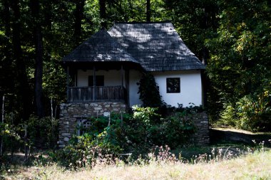 Geleneksel Romen tarzında ev, basitlik ve alçakgönüllülük, fayda ve doğal malzemeler, katı mimari, doğayla ilişkili olarak yapılmış, kapı eşiği kısa, pencereler küçük