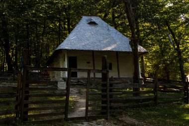 Geleneksel Romen tarzında ev, basitlik ve alçakgönüllülük, fayda ve doğal malzemeler, katı mimari, doğayla ilişkili olarak yapılmış, kapı eşiği kısa, pencereler küçük