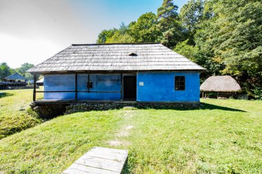 Geleneksel Romen tarzında ev, basitlik ve alçakgönüllülük, fayda ve doğal malzemeler, katı mimari, doğayla ilişkili olarak yapılmış, kapı eşiği kısa, pencereler küçük