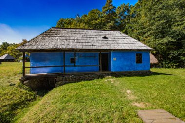 Geleneksel Romen tarzında ev, basitlik ve alçakgönüllülük, fayda ve doğal malzemeler, katı mimari, doğayla ilişkili olarak yapılmış, kapı eşiği kısa, pencereler küçük