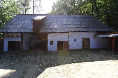 Geleneksel Romen tarzında ev, basitlik ve alçakgönüllülük, fayda ve doğal malzemeler, katı mimari, doğayla ilişkili olarak yapılmış, kapı eşiği kısa, pencereler küçük