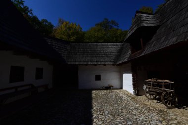 Geleneksel Romen tarzında ev, basitlik ve alçakgönüllülük, fayda ve doğal malzemeler, katı mimari, doğayla ilişkili olarak yapılmış, kapı eşiği kısa, pencereler küçük