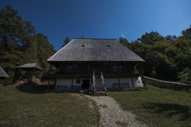 Geleneksel Romen tarzında ev, basitlik ve alçakgönüllülük, fayda ve doğal malzemeler, katı mimari, doğayla ilişkili olarak yapılmış, kapı eşiği kısa, pencereler küçük