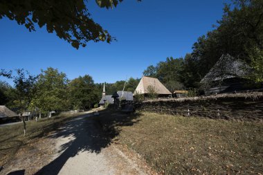 Geleneksel Romen tarzında ev, basitlik ve alçakgönüllülük, fayda ve doğal malzemeler, katı mimari, doğayla ilişkili olarak yapılmış, kapı eşiği kısa, pencereler küçük