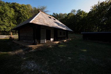 Geleneksel Romen tarzında ev, basitlik ve alçakgönüllülük, fayda ve doğal malzemeler, katı mimari, doğayla ilişkili olarak yapılmış, kapı eşiği kısa, pencereler küçük