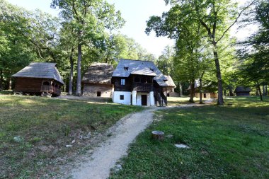 Geleneksel Romen tarzında ev, basitlik ve alçakgönüllülük, fayda ve doğal malzemeler, katı mimari, doğayla ilişkili olarak yapılmış, kapı eşiği kısa, pencereler küçük