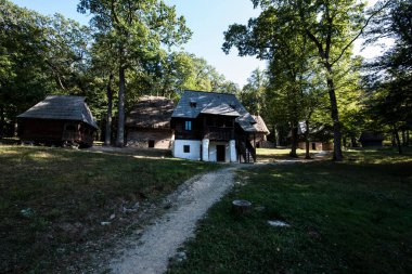 Geleneksel Romen tarzında ev, basitlik ve alçakgönüllülük, fayda ve doğal malzemeler, katı mimari, doğayla ilişkili olarak yapılmış, kapı eşiği kısa, pencereler küçük