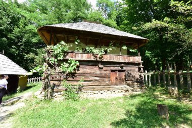 Geleneksel Romen tarzında ev, basitlik ve alçakgönüllülük, fayda ve doğal malzemeler, katı mimari, doğayla ilişkili olarak yapılmış, kapı eşiği kısa, pencereler küçük