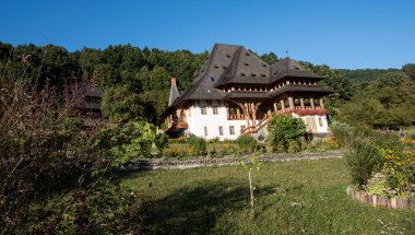 Brsana 'daki Ortodoks Manastırı, Ortodoks tarikatının geleneksel ahşap ve taş yapıları olan Maramure Valea Izei' den gelen kırmızı çiçeklerin hakim olduğu doğal alanda bulunan bir manastır kompleksi.