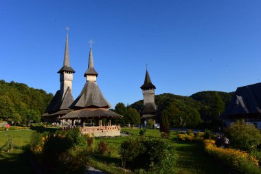 Brsana 'daki Ortodoks Manastırı, Ortodoks tarikatının geleneksel ahşap ve taş yapıları olan Maramure Valea Izei' den gelen kırmızı çiçeklerin hakim olduğu doğal alanda bulunan bir manastır kompleksi.