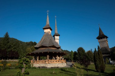 Brsana 'daki Ortodoks Manastırı, Ortodoks tarikatının geleneksel ahşap ve taş yapıları olan Maramure Valea Izei' den gelen kırmızı çiçeklerin hakim olduğu doğal alanda bulunan bir manastır kompleksi.