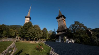 Brsana 'daki Ortodoks Manastırı, Ortodoks tarikatının geleneksel ahşap ve taş yapıları olan Maramure Valea Izei' den gelen kırmızı çiçeklerin hakim olduğu doğal alanda bulunan bir manastır kompleksi.