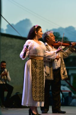 TARGU JIU, ROMANIA, MAYIS 25, 2018 GORJA Halk kostümlü sanatçılar Kadınlar için takım elbise bel, kalça ve ön, ve erkekler için gömlek, pantolon, yelek ve kemer.