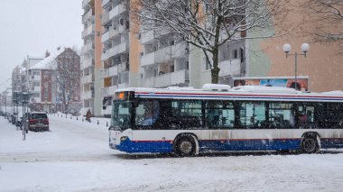 KOLOBRZEG, BATI POLAND - 2021: Karlı bir sokakta toplu taşıma otobüsü 