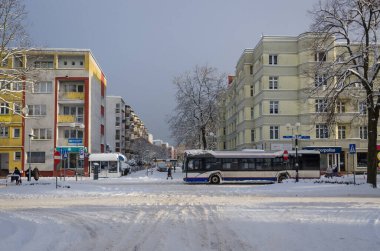 KOLOBRZEG, BATI POLAND - 2021: Karlı bir sokakta toplu taşıma otobüsü 