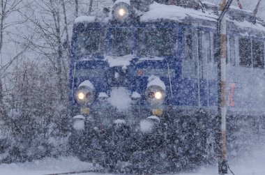 KARLINO - BATI POMERANYA - PLAND - 2021: Yolcu ekspresinin lokomotifi kar fırtınasında tren yolunda