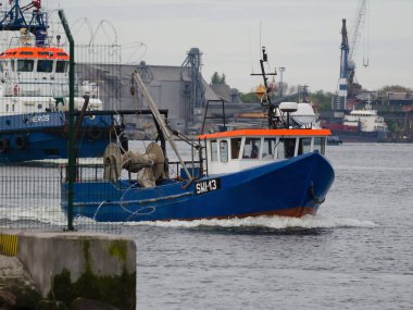 SWINOUJSCIE, WEST POMERANIAN / POLAND - 2020: A fishing boat and a tug go to the sea 