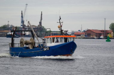 SWINOUJSCIE, WEST POMERANIAN / POLAND - 2020: A fishing boat and a tug go to the sea 