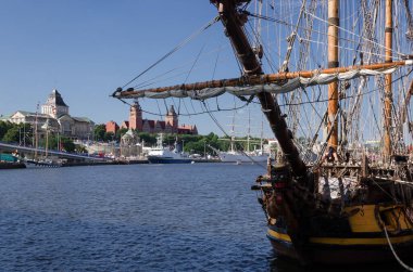 SZCZECIN, BATI POLAND - 2021; Rıhtımdaki Rus firkateyn SHTANDART şehrin arka planına ve diğer yelkenli gemilere karşı