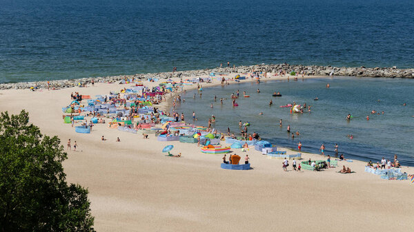 JAROSLAWIEC, WEST POMERANIAN - POLAND - 2021: Holidaymakers relacreation on the sunny sea beach
