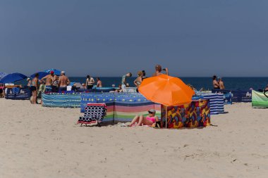 SARBINOWO, BATI POMERANYA / POLAND - 2021: Güneşli deniz plajında tatilciler yeniden yaratılıyor